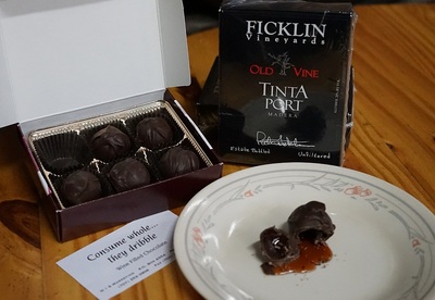 A 6-count box of Old Vine Tinta filled chocolate candies and one cut open showing the Port liquid Port filling coming out.