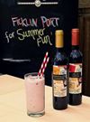 A bottle of Ficklin Vineyards' Raspberry PassPort and a bottle of Chocolate PassPort next to a tall glass with straws containing a milkshake make with vanilla ice cream and Port.