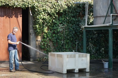 Winemaker Peter Ficklin hosing out grape bins at the end of a long crush day.