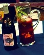 Garnished pitcher of Ruby Sangria next to bottle of Brisa Ruby Port